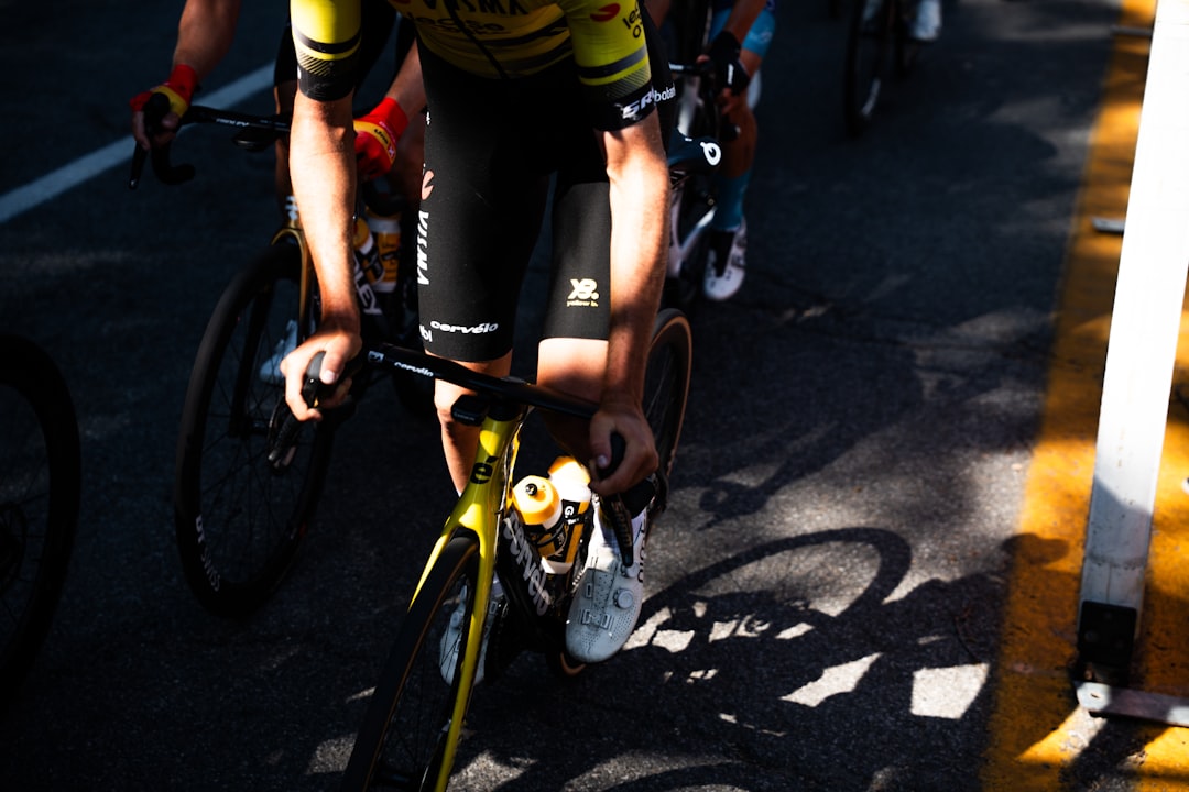 Close-up of a cyclist pedaling on a road bike with a power meter visible.