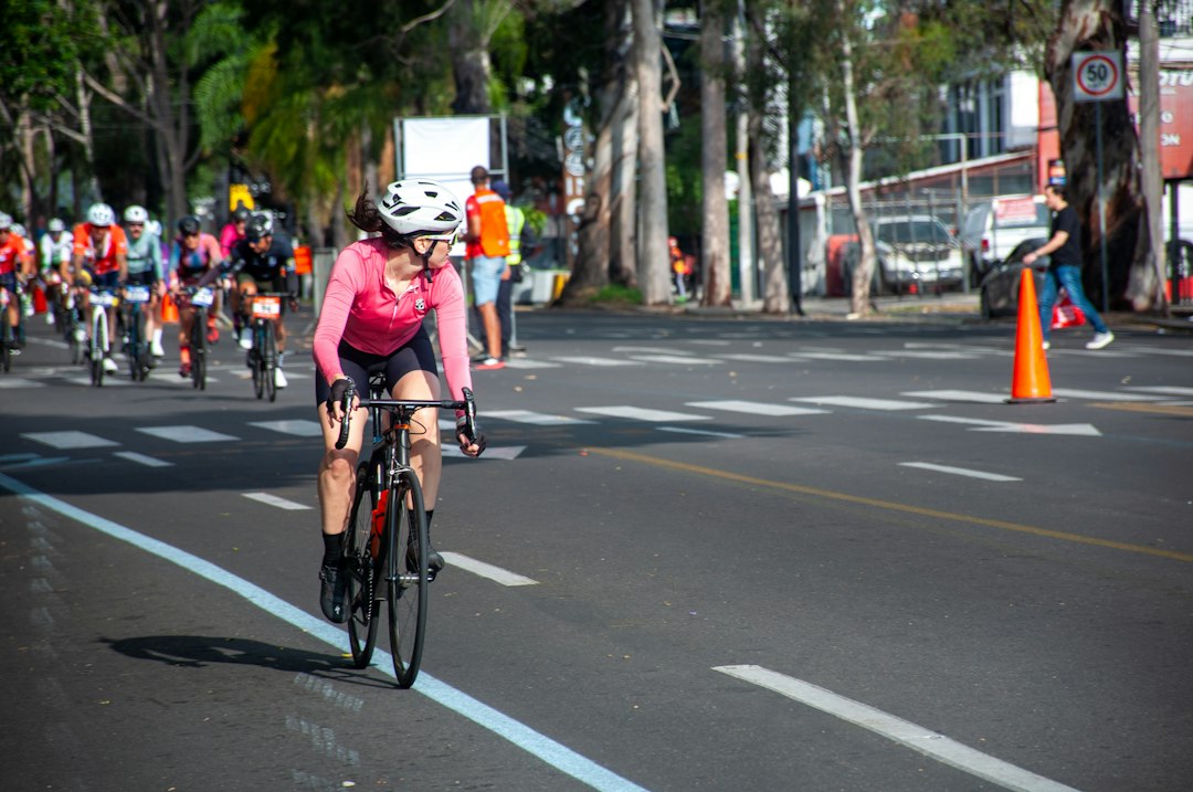 Close-up of a cyclist pedaling on a road bike with a power meter visible.
