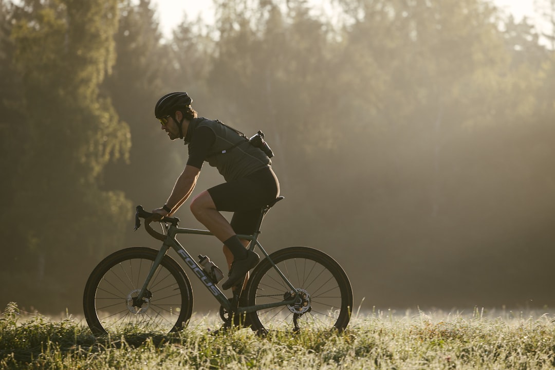 Close-up of a cyclist pedaling on a road bike with a power meter visible.