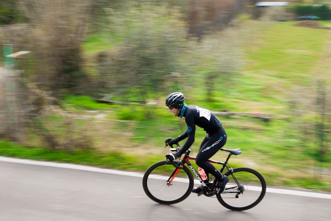 Close-up of a cyclist pedaling on a road bike with a power meter visible.