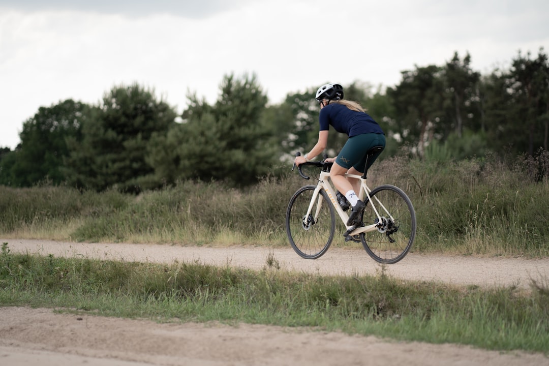 Close-up of a cyclist pedaling on a road bike with a power meter visible.