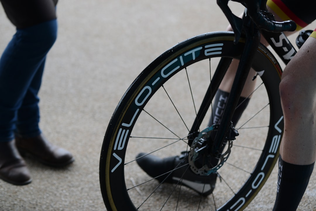 Close-up of a cyclist pedaling on a road bike with a power meter visible.