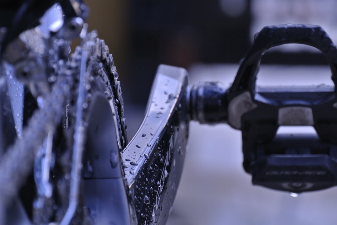 Close-up of a cyclist pedaling on a road bike with a power meter visible.