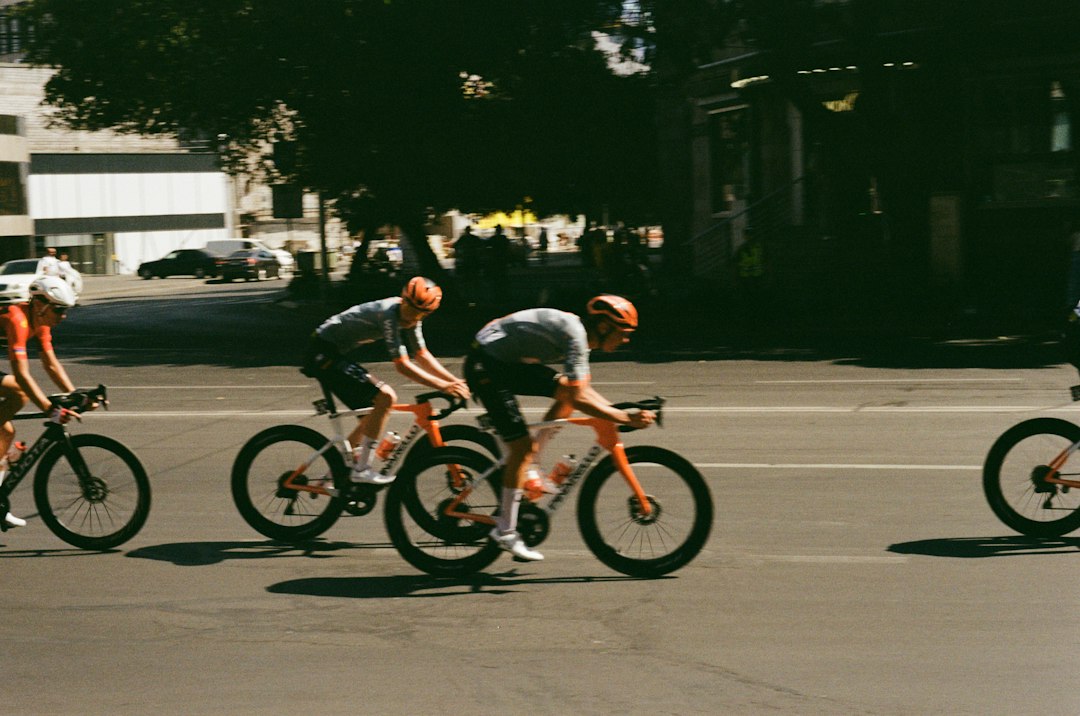 Close-up of a cyclist pedaling on a road bike with a power meter visible.