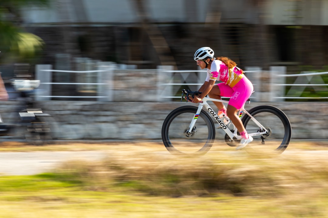 Close-up of a cyclist pedaling on a road bike with a power meter visible.