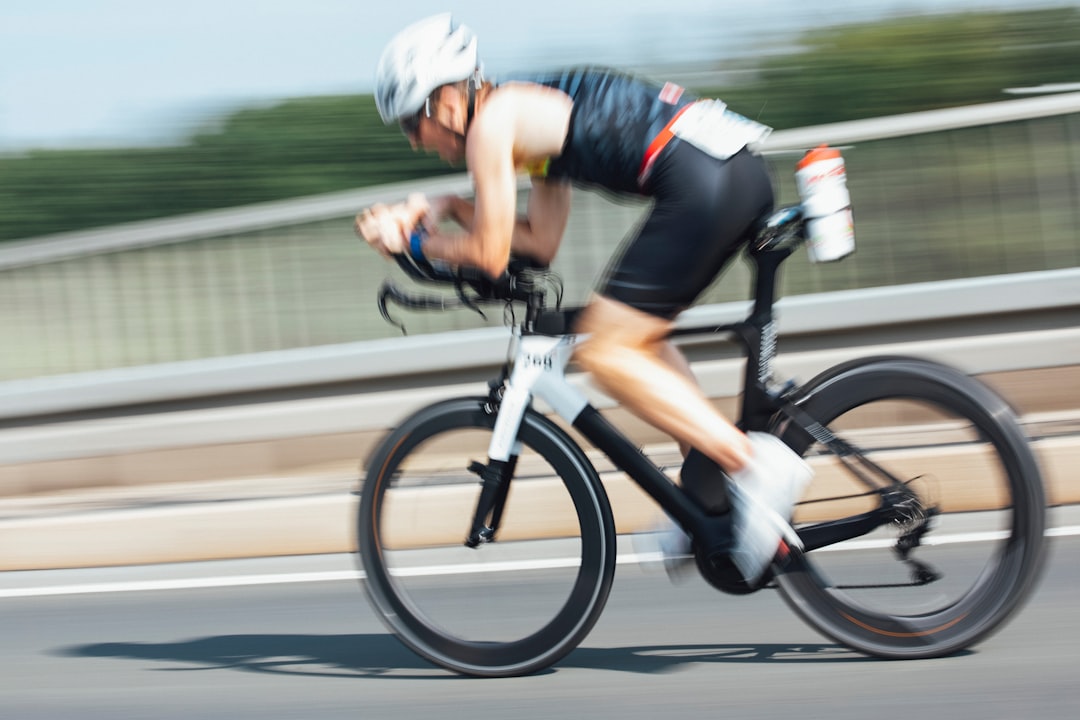 Close-up of a cyclist pedaling on a road bike with a power meter visible.