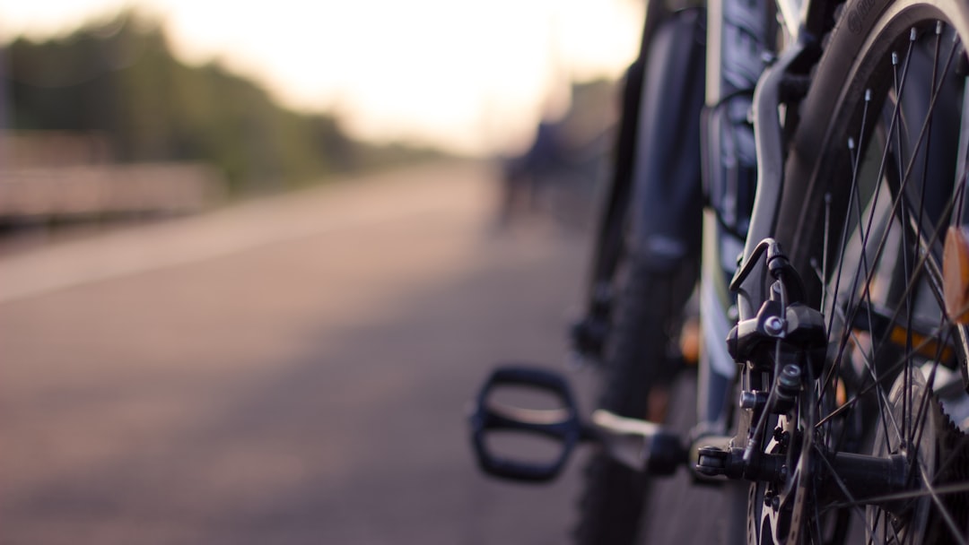Close-up of a cyclist pedaling on a road bike with a power meter visible.