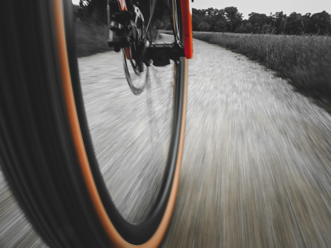 Close-up of a cyclist pedaling on a road bike with a power meter visible.