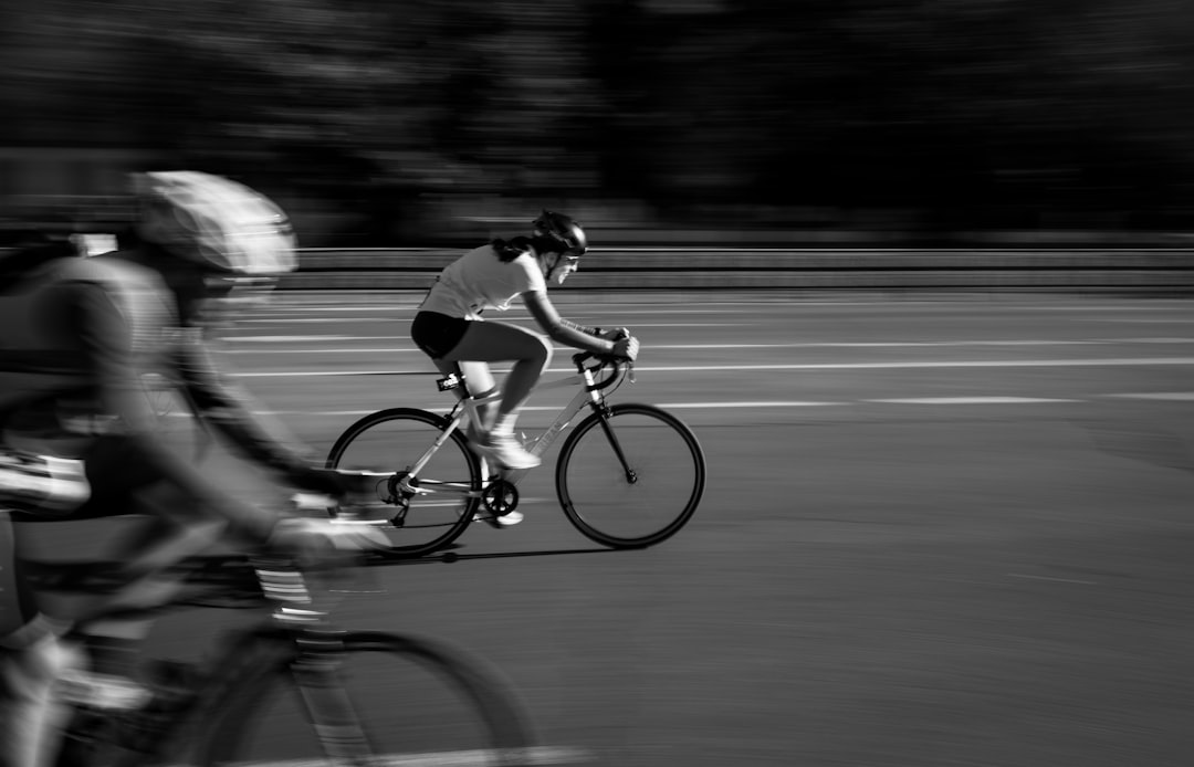 Close-up of a cyclist pedaling on a road bike with a power meter visible.