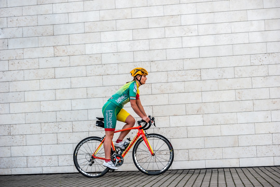 Close-up of a cyclist pedaling on a road bike with a power meter visible.