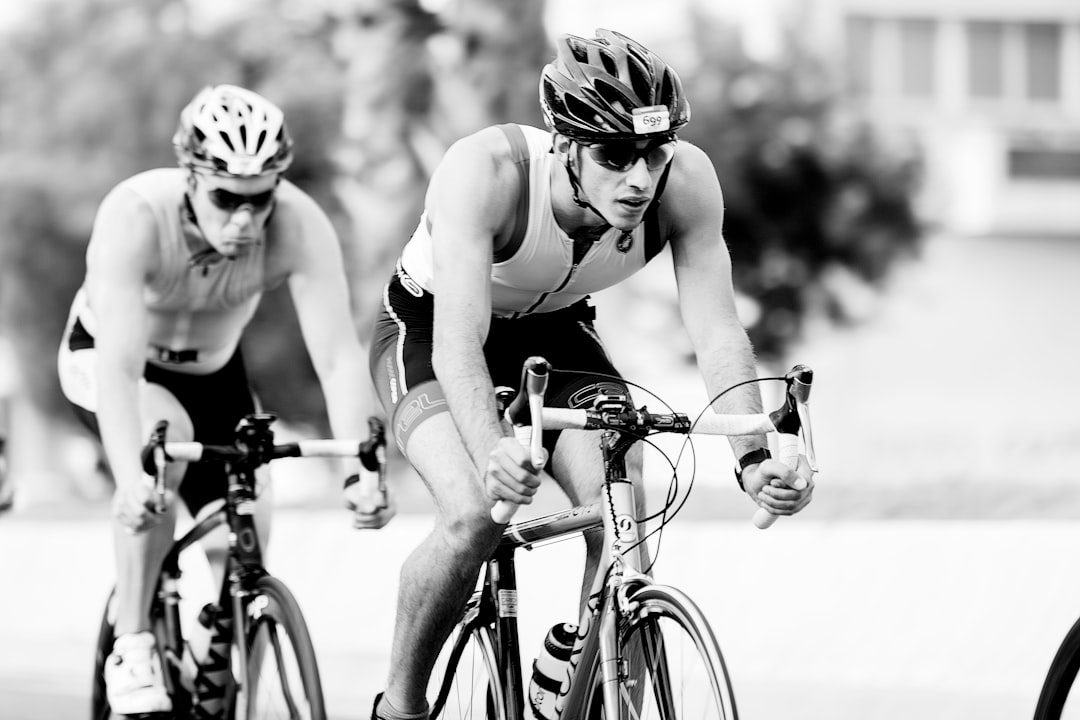 Close-up of a cyclist pedaling on a road bike with a power meter visible.