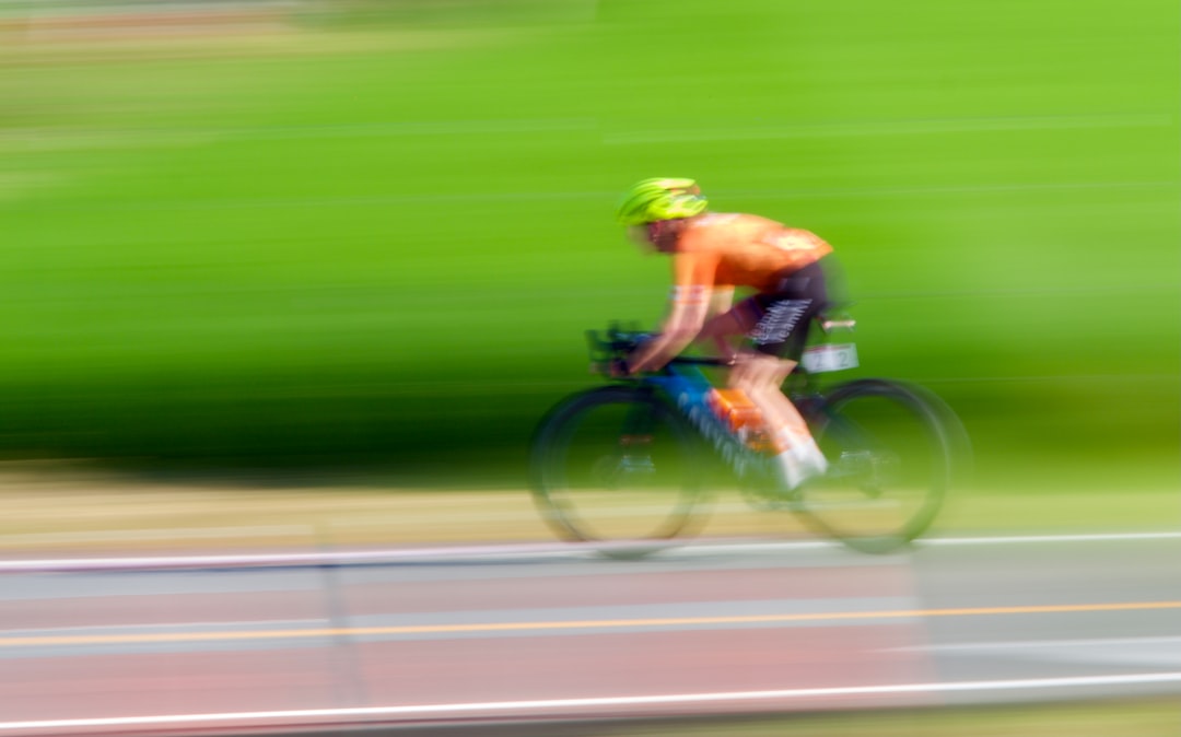 Close-up of a cyclist pedaling on a road bike with a power meter visible.