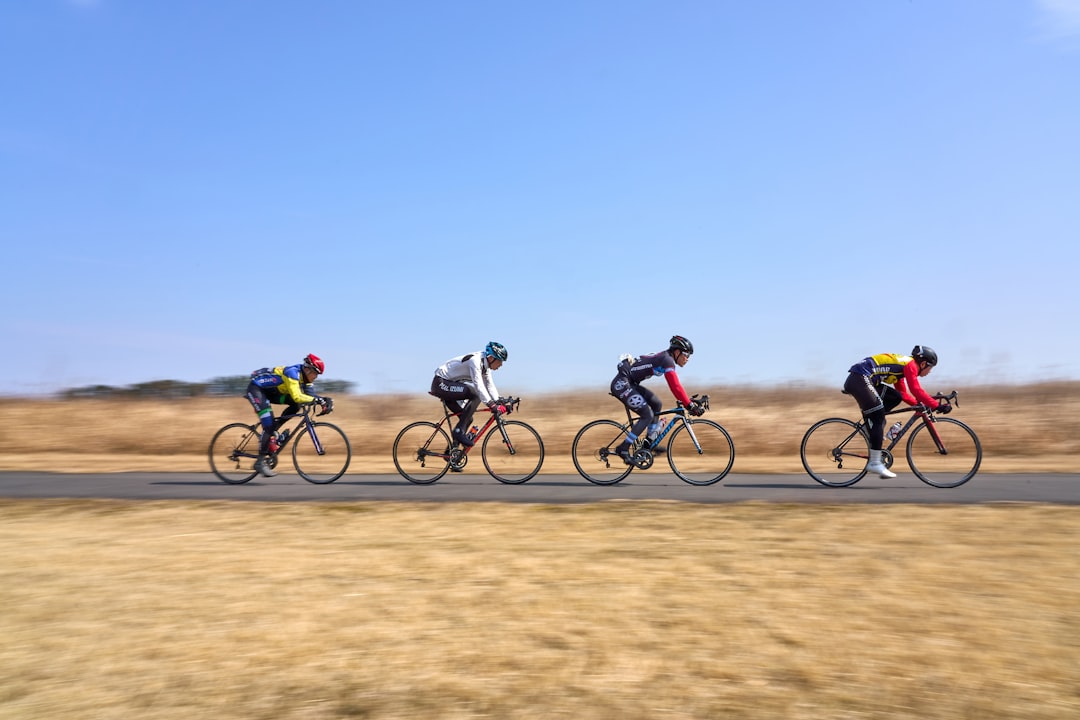 Group of road cyclists riding together outdoors on paved roads.
