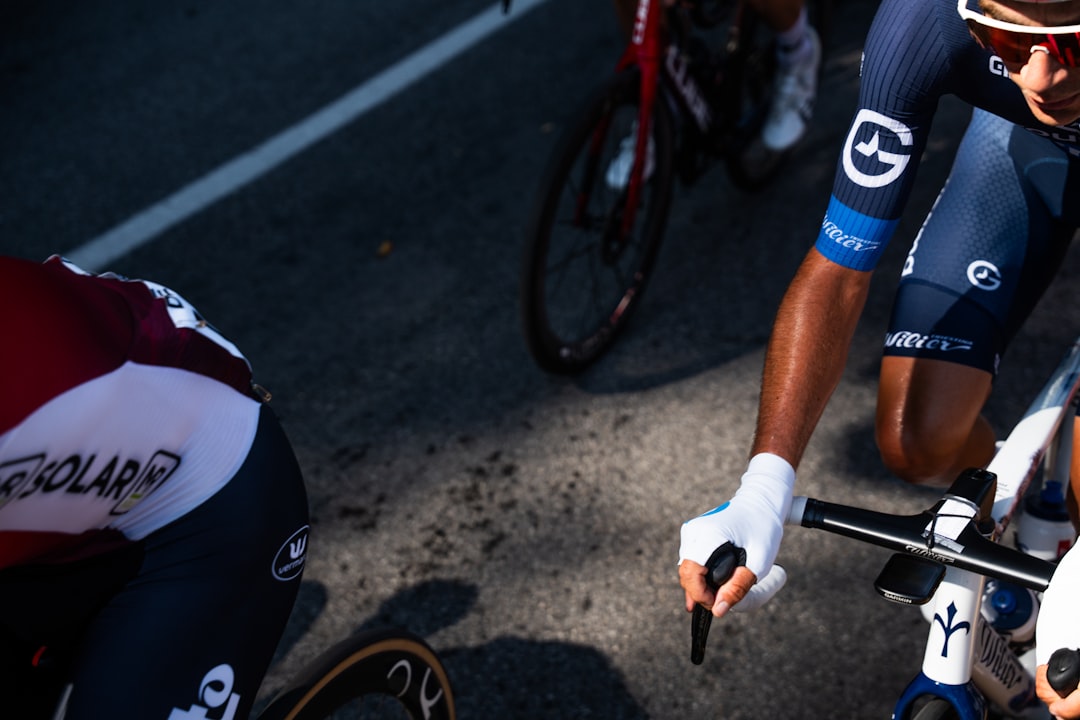Close-up of a cyclist pedaling on a road bike with a power meter visible.
