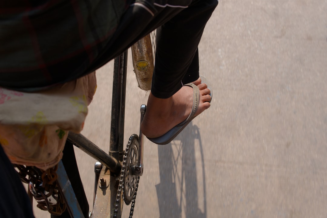 Close-up of a cyclist pedaling on a road bike with a power meter visible.
