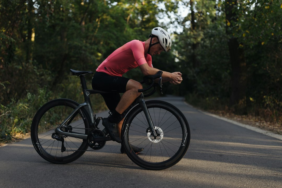 Close-up of a cyclist pedaling on a road bike with a power meter visible.