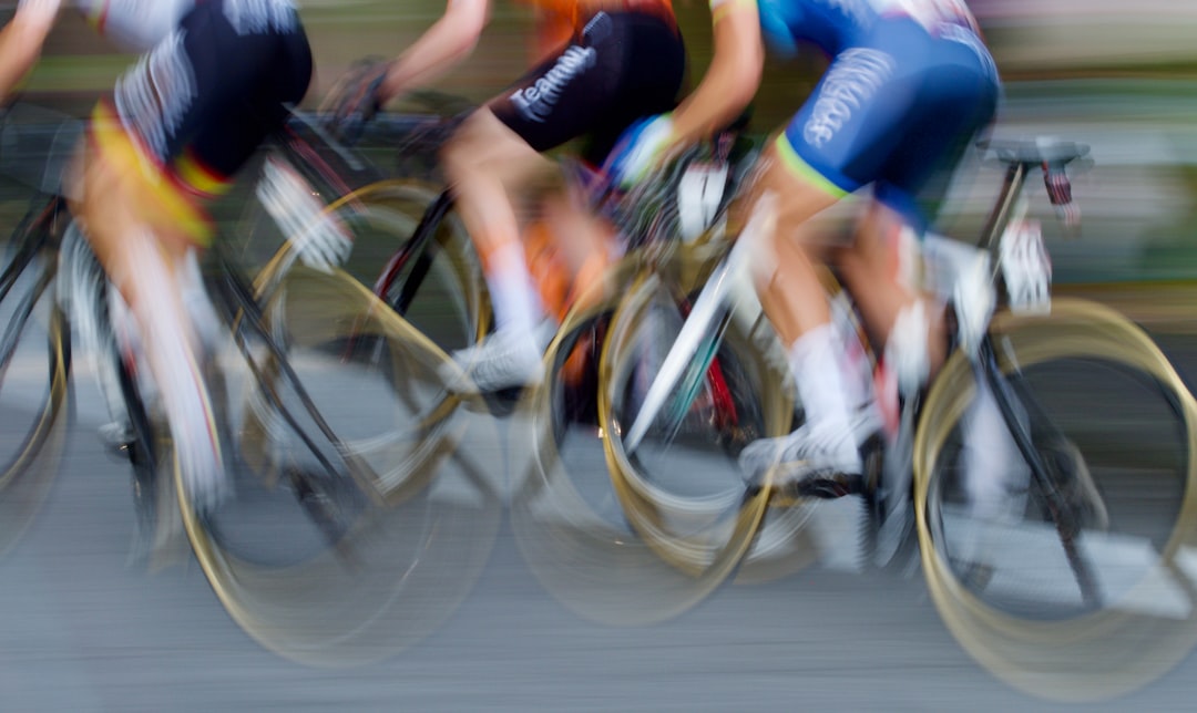 Close-up of a cyclist pedaling on a road bike with a power meter visible.