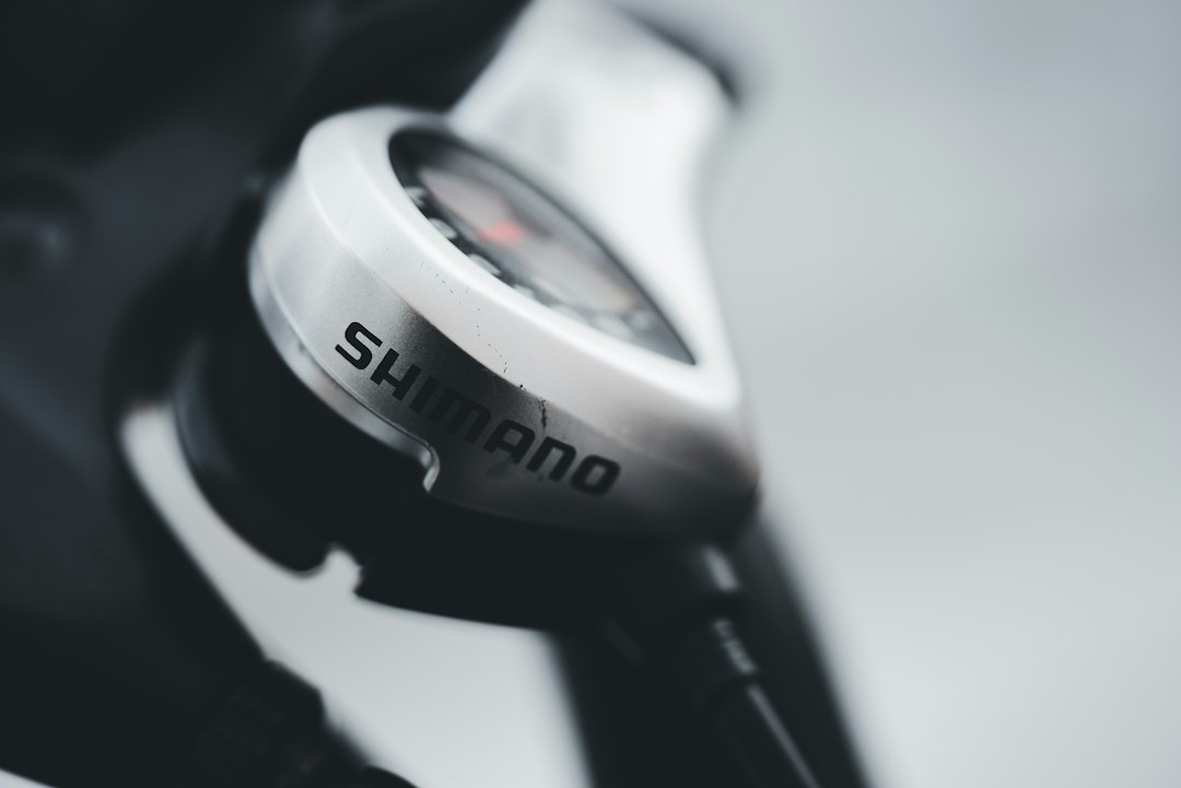 Close-up of a cyclist pedaling on a road bike with a power meter visible.