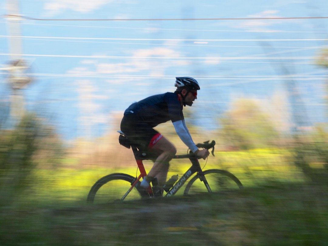 Close-up of a cyclist pedaling on a road bike with a power meter visible.