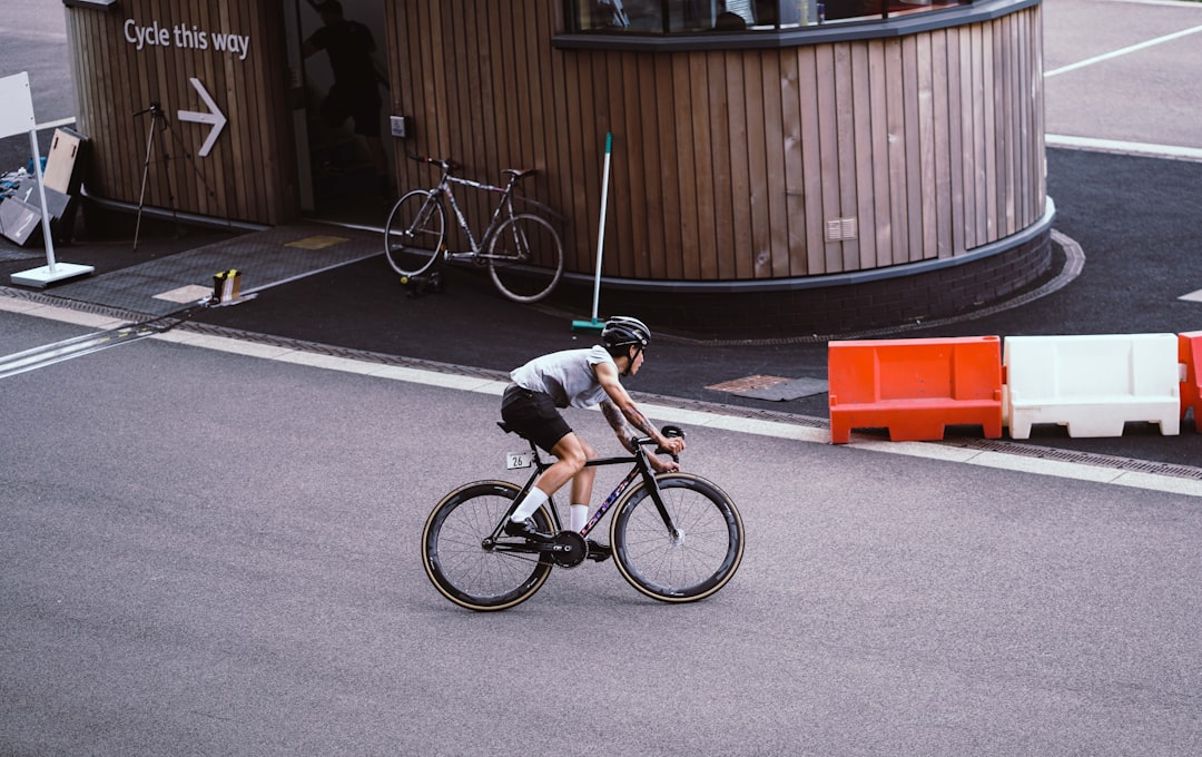 Close-up of a cyclist pedaling on a road bike with a power meter visible.