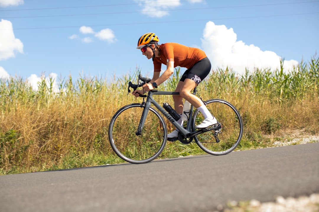 Close-up of a cyclist pedaling on a road bike with a power meter visible.