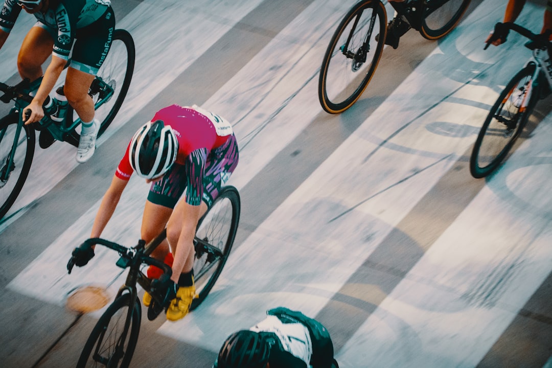 Close-up of a cyclist pedaling on a road bike with a power meter visible.