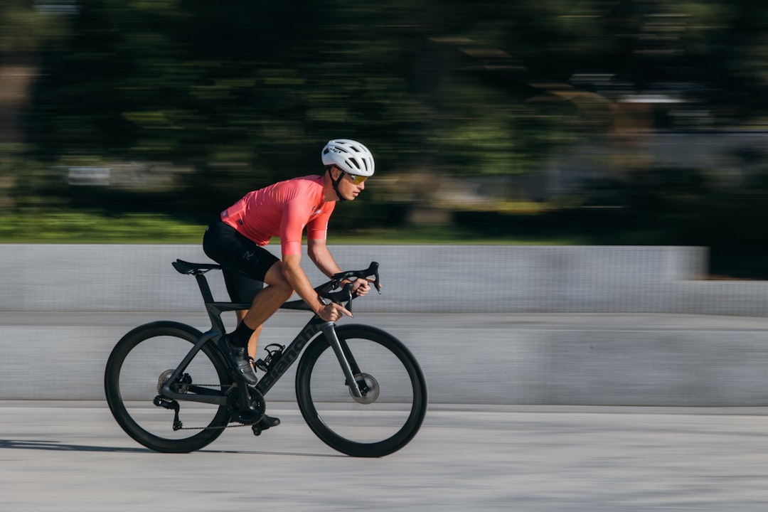 Close-up of a cyclist pedaling on a road bike with a power meter visible.