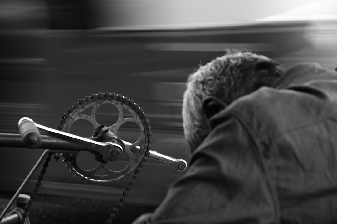 Close-up of a cyclist pedaling on a road bike with a power meter visible.