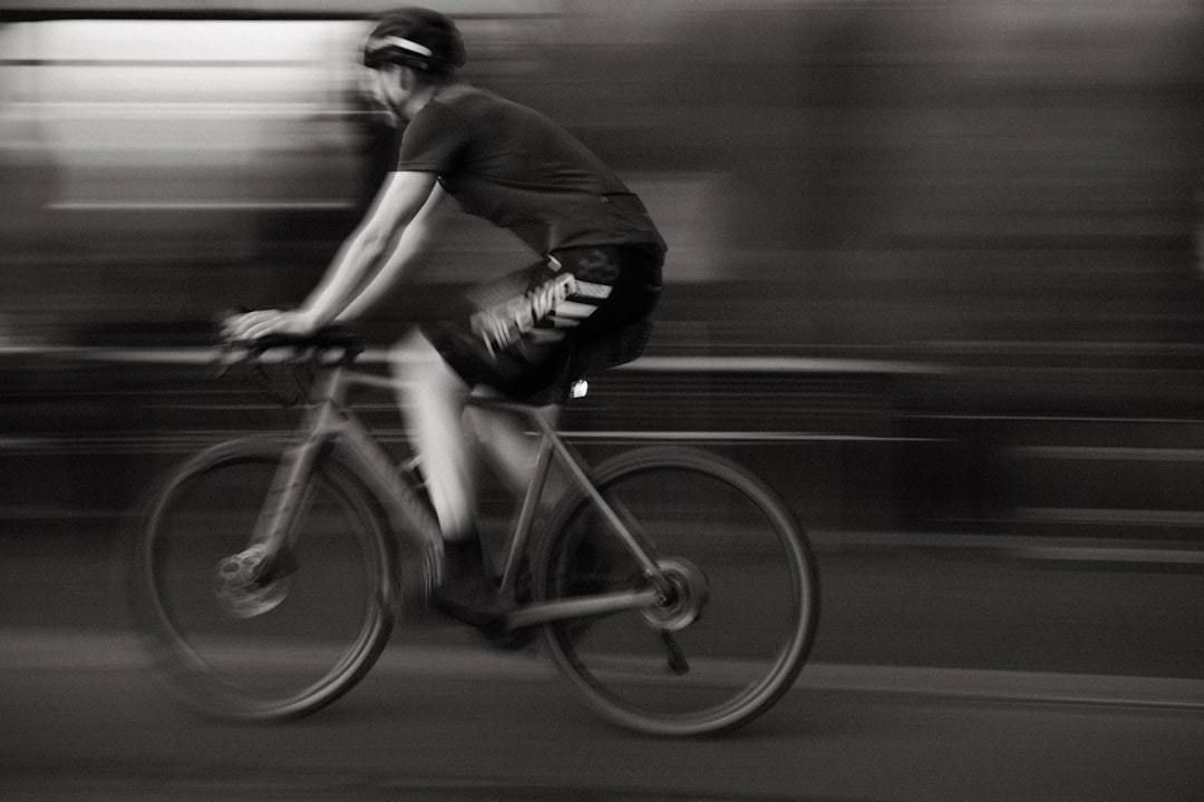 Close-up of a cyclist pedaling on a road bike with a power meter visible.