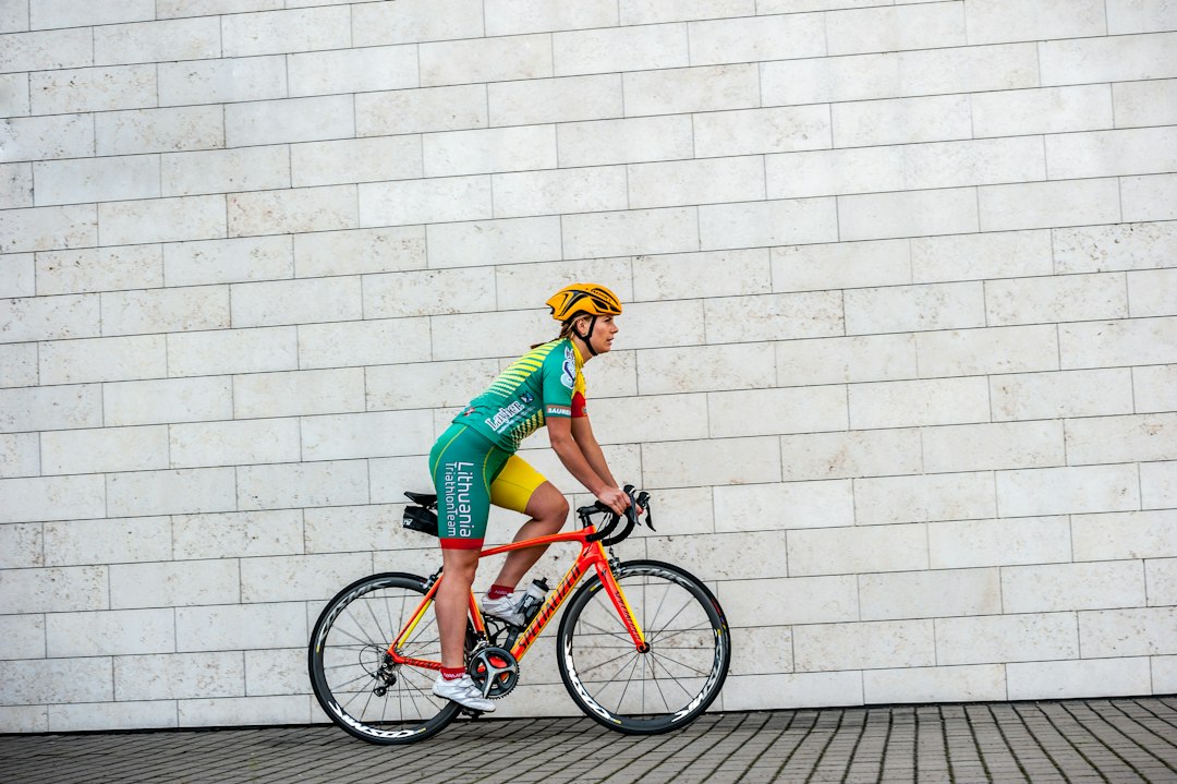 Close-up of a cyclist pedaling on a road bike with a power meter visible.
