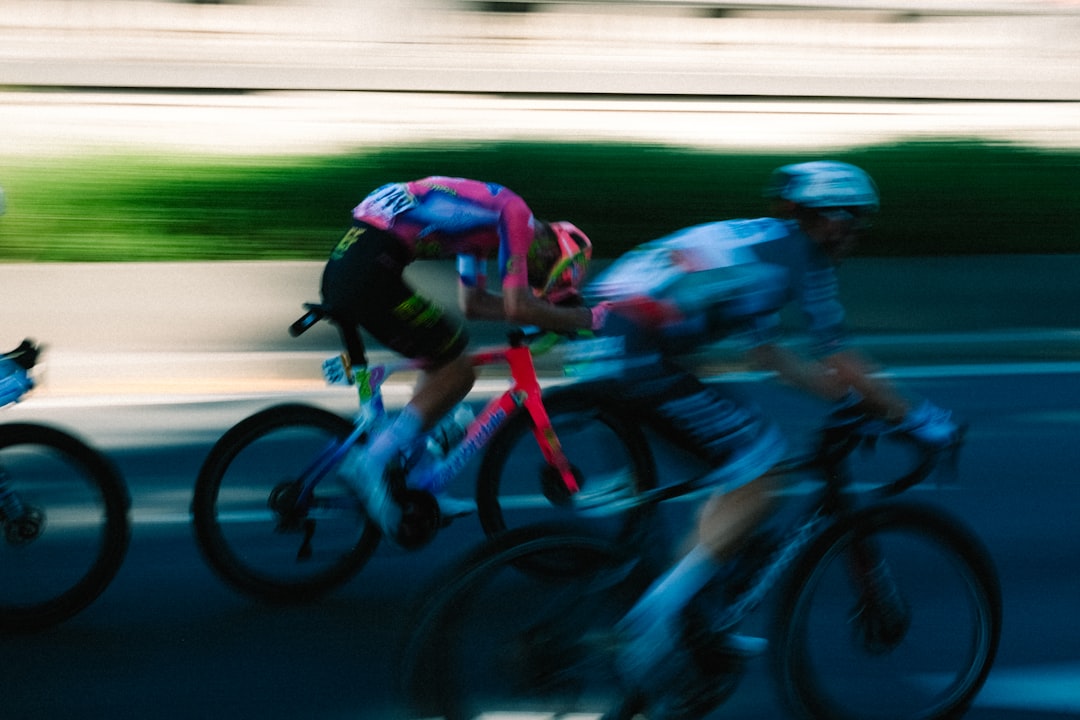 Close-up of a cyclist pedaling on a road bike with a power meter visible.
