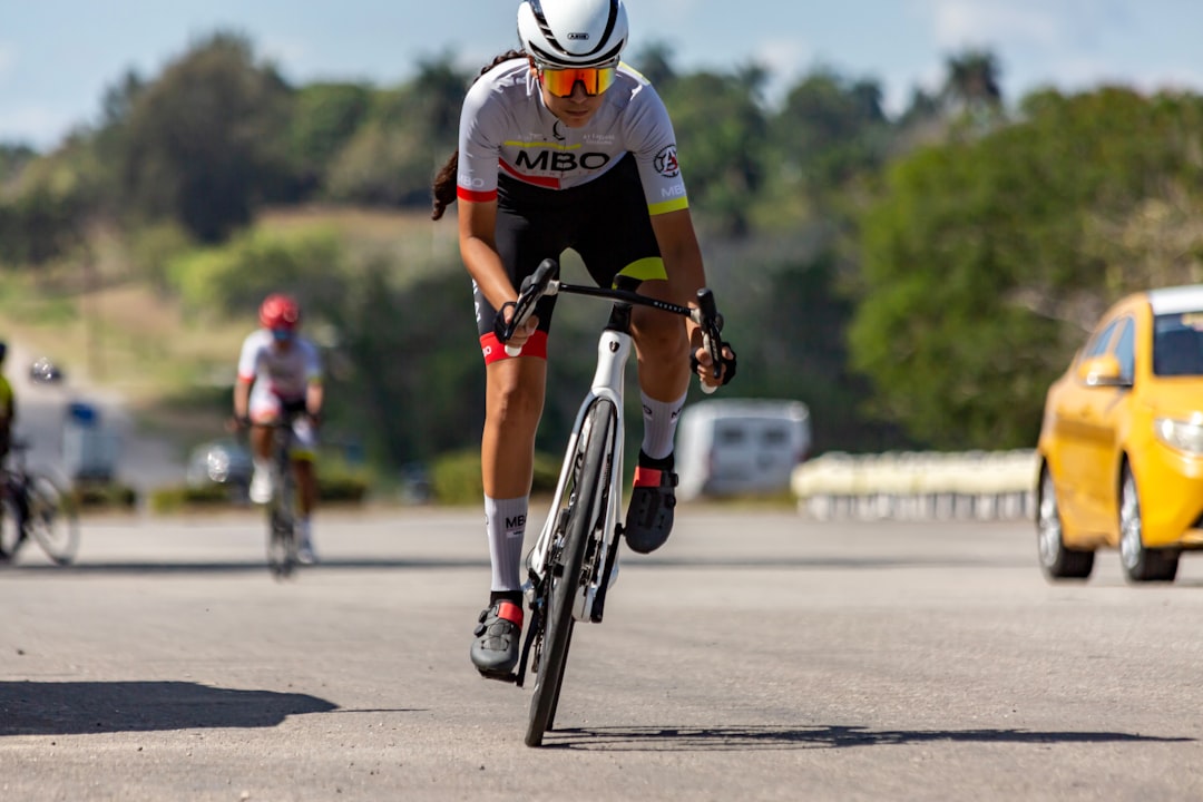 Close-up of a cyclist pedaling on a road bike with a power meter visible.