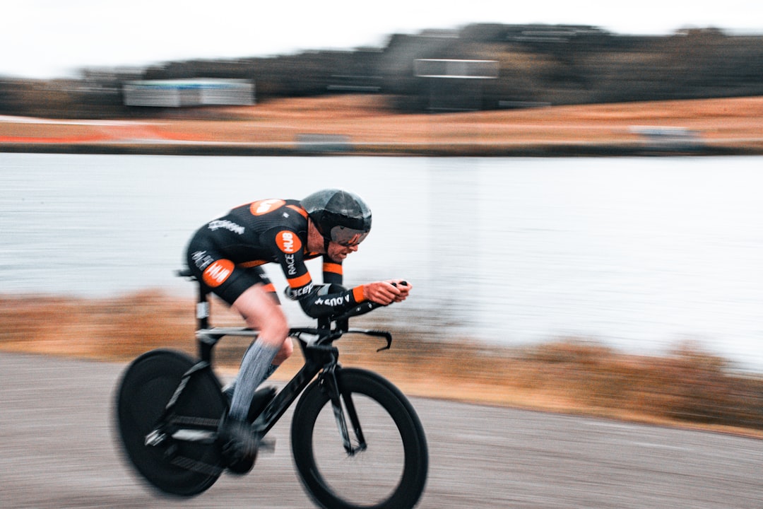 Close-up of a cyclist pedaling on a road bike with a power meter visible.