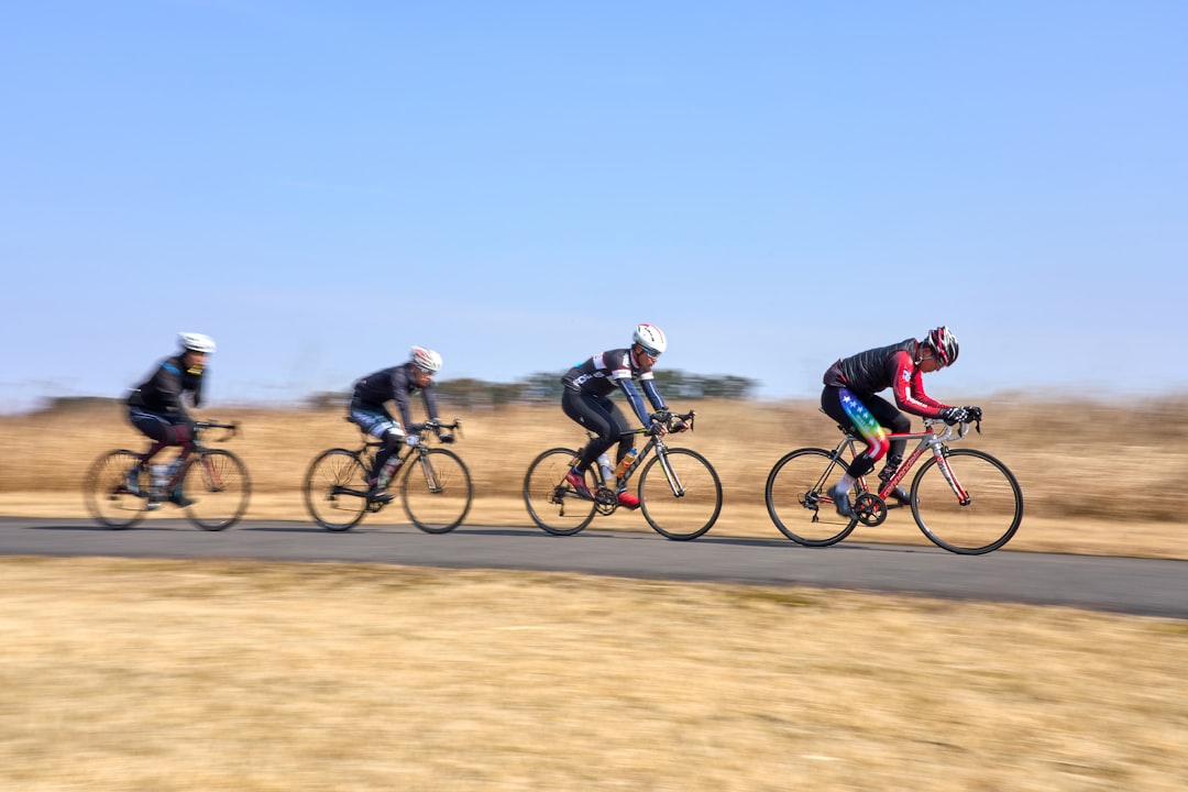 Close-up of a cyclist pedaling on a road bike with a power meter visible.