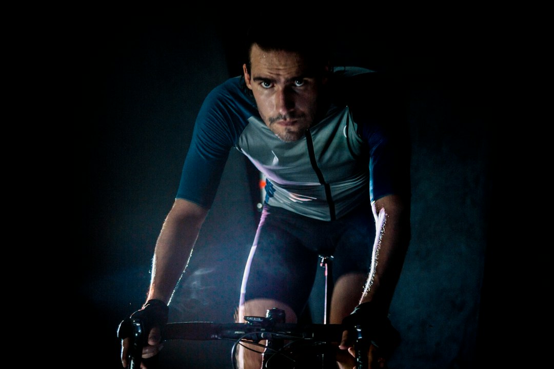 Close-up of a cyclist pedaling on a road bike with a power meter visible.
