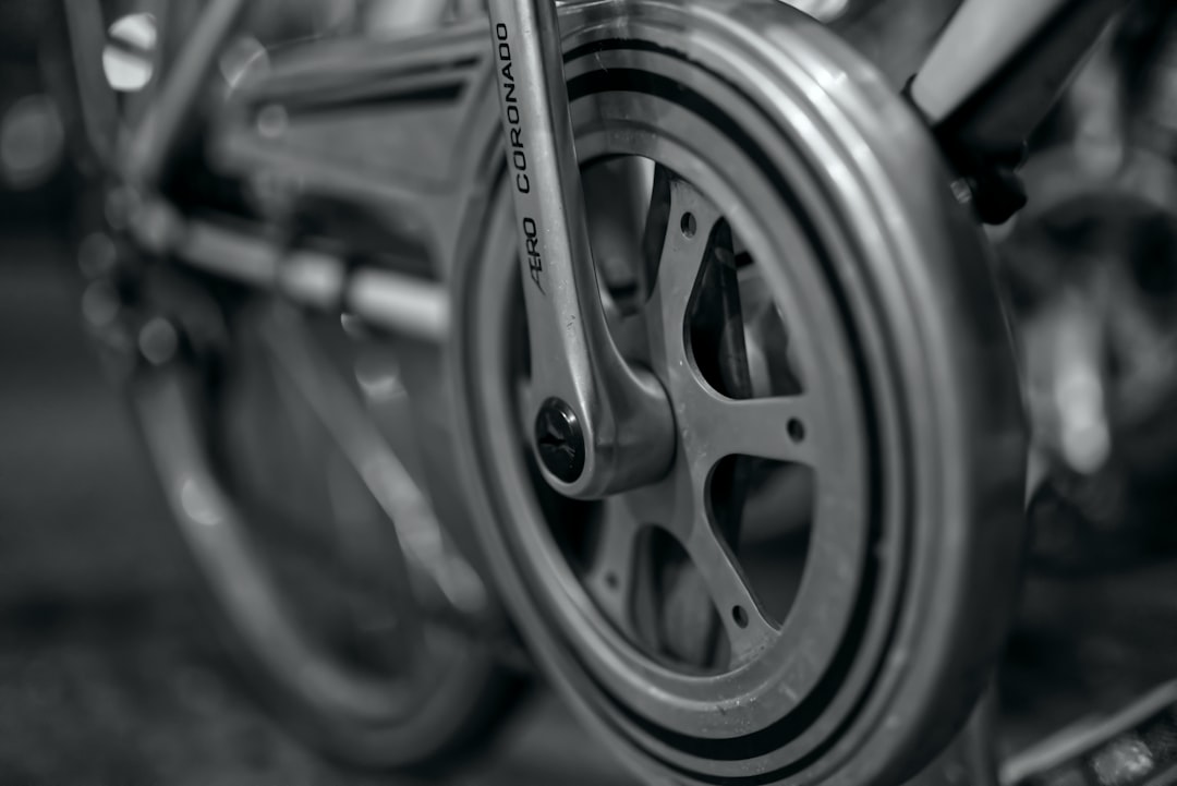Close-up of a cyclist pedaling on a road bike with a power meter visible.