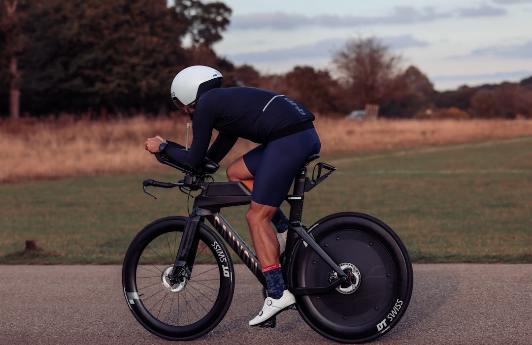 Close-up of a cyclist pedaling on a road bike with a power meter visible.