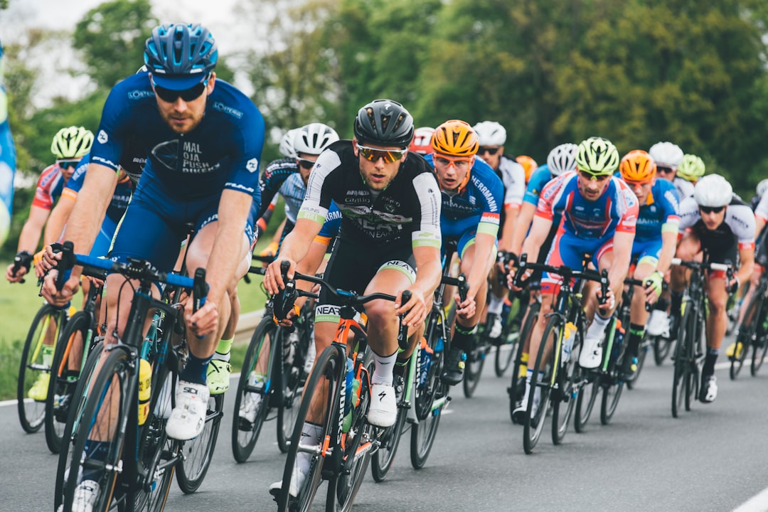 Group of road cyclists riding together outdoors on paved roads.