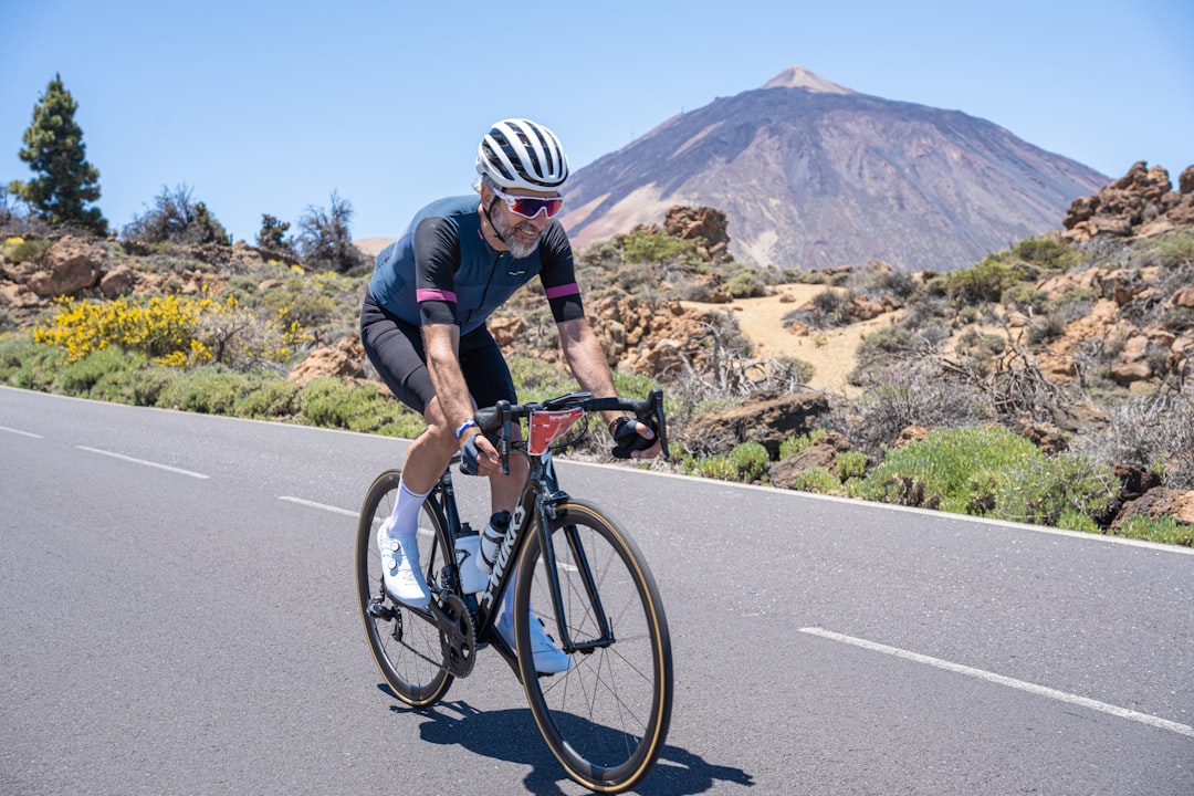Close-up of a cyclist pedaling on a road bike with a power meter visible.