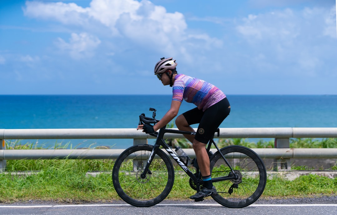 Close-up of a cyclist pedaling on a road bike with a power meter visible.