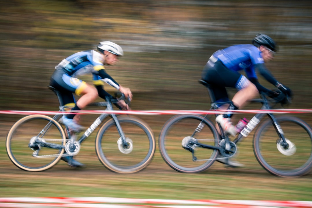 Close-up of a cyclist pedaling on a road bike with a power meter visible.