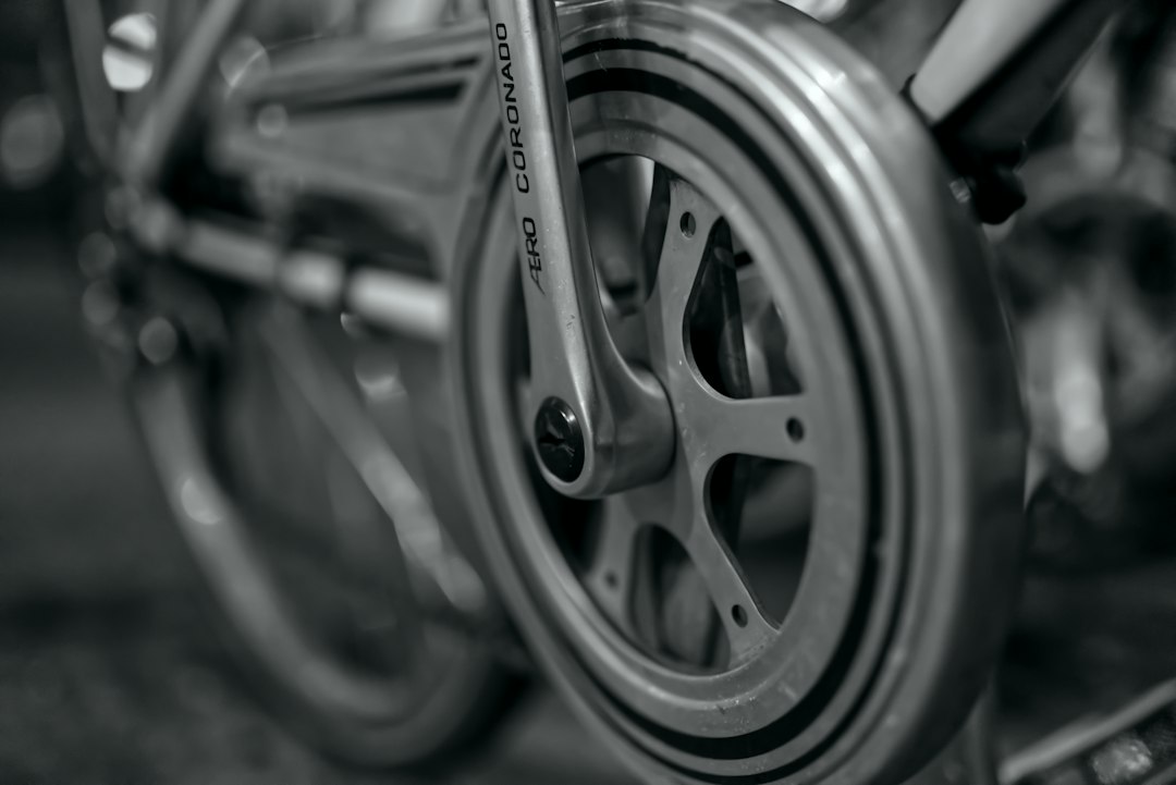 Close-up of a cyclist pedaling on a road bike with a power meter visible.