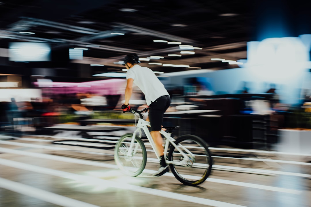 Close-up of a cyclist pedaling on a road bike with a power meter visible.