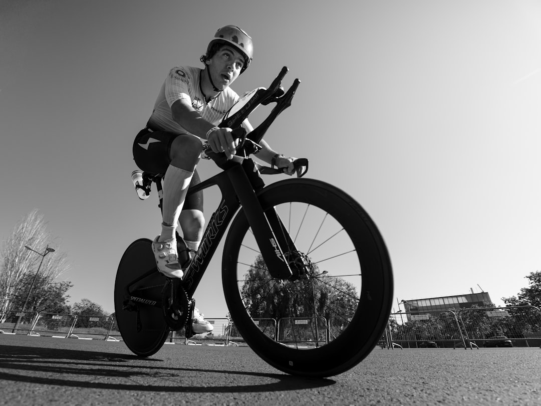 Close-up of a cyclist pedaling on a road bike with a power meter visible.