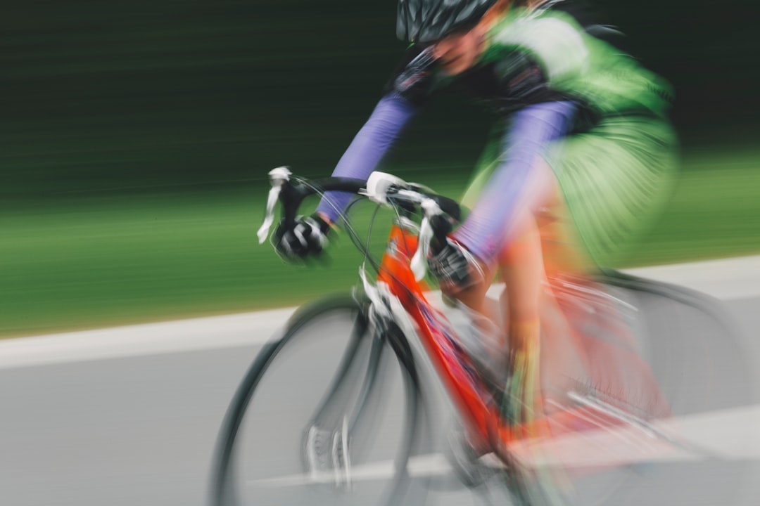 Close-up of a cyclist pedaling on a road bike with a power meter visible.
