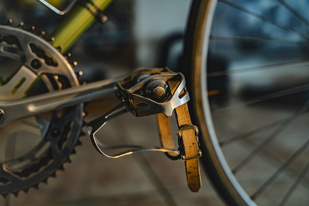 Close-up of a cyclist pedaling on a road bike with a power meter visible.