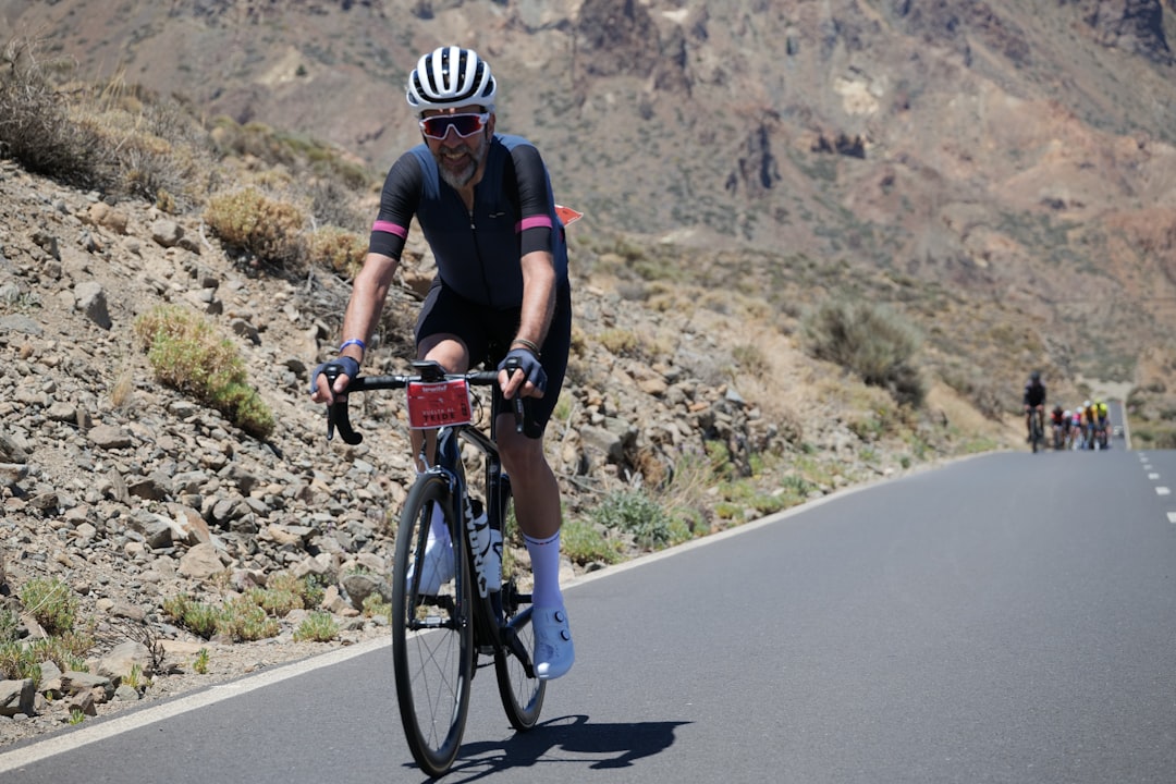 Close-up of a cyclist pedaling on a road bike with a power meter visible.
