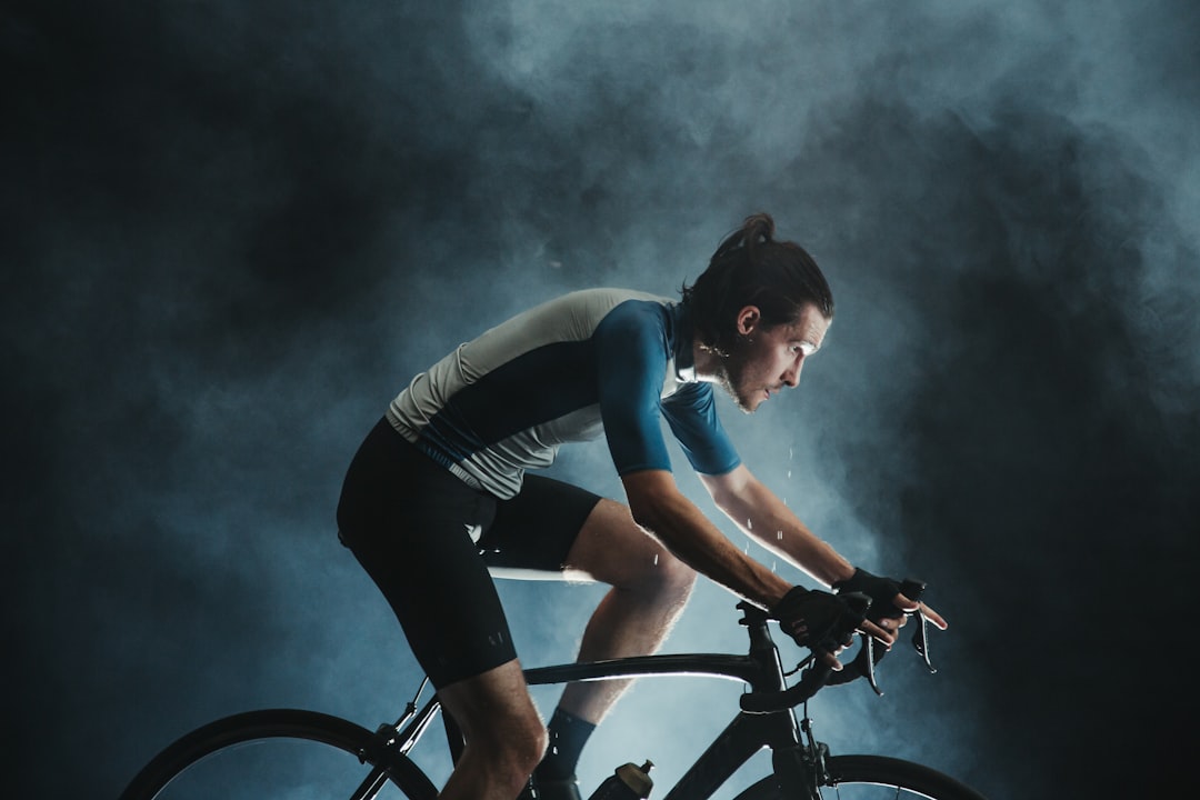 Close-up of a cyclist pedaling on a road bike with a power meter visible.
