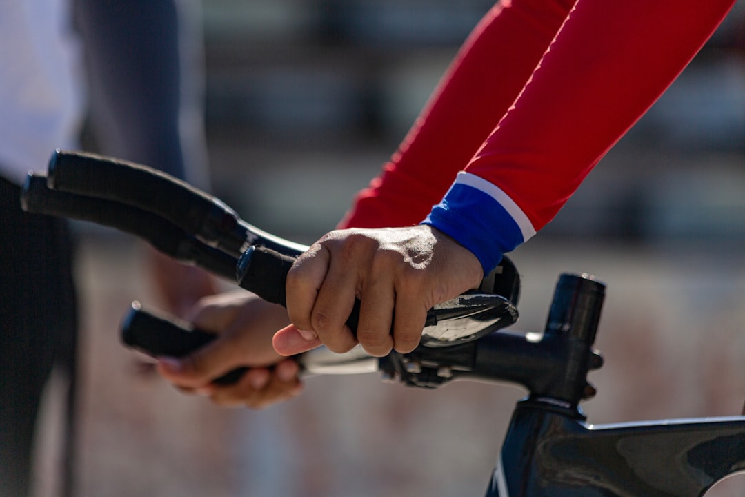Close-up of a cyclist pedaling on a road bike with a power meter visible.