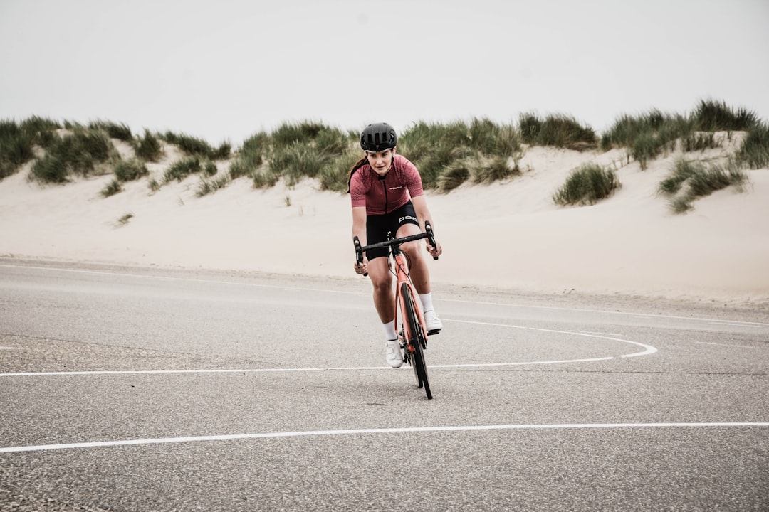 Close-up of a cyclist pedaling on a road bike with a power meter visible.